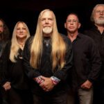 A group of people with long hair and beards posing for a photo.