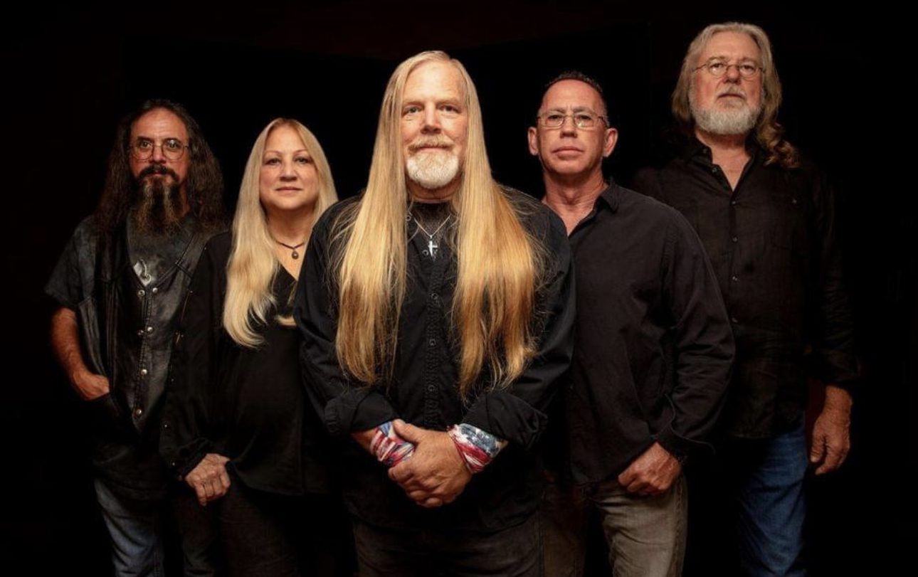 A group of people with long hair and beards posing for a photo.