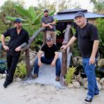 Four men posing on small tropical bridge