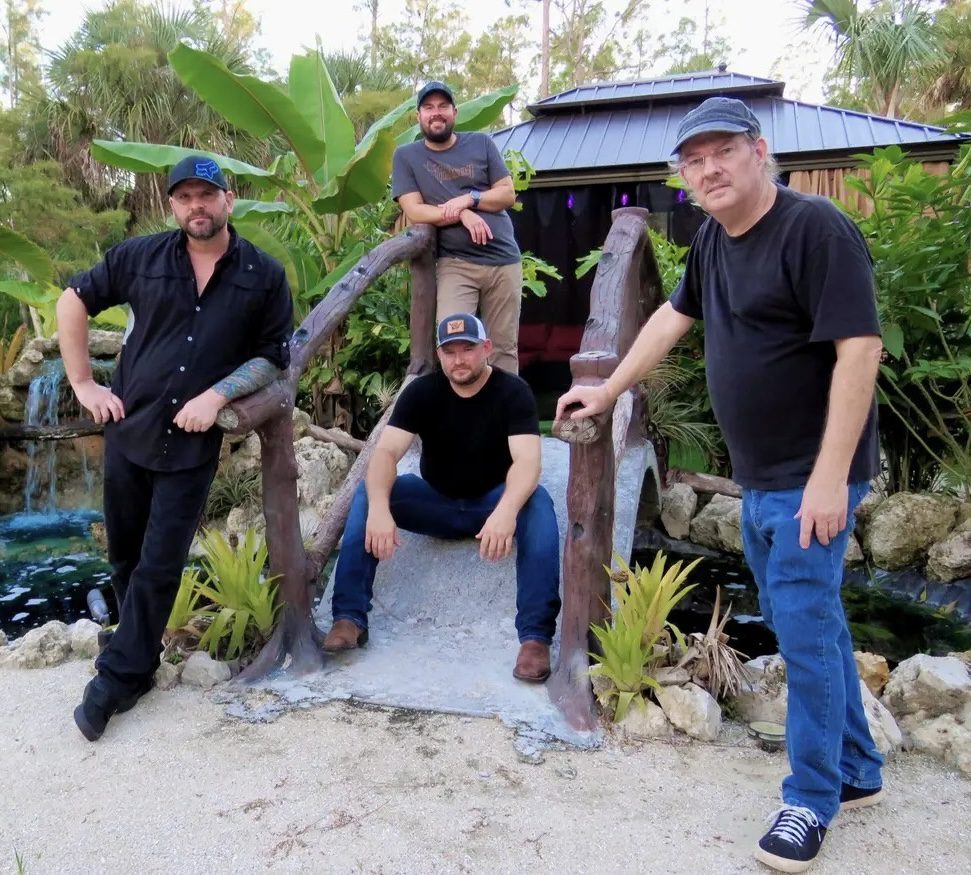 Four men posing on small tropical bridge